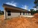 New house with siding and a chimney, a concrete pad is ready for a patio, set against a treed horizon at 5381 Tuscany Dr, Douglasville, GA 30135