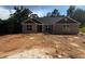 Traditional brick home with a contemporary roof and trim awaiting landscaping at 5381 Tuscany Dr, Douglasville, GA 30135