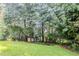 Green backyard featuring a shed and mature trees at 3604 Cameron Hills Pl, Ellenwood, GA 30294