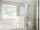 Well-lit bathroom featuring a separate tub and shower, with a window providing natural light at 3604 Cameron Hills Pl, Ellenwood, GA 30294