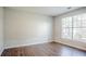 Bright bedroom featuring a large window, natural light, and vinyl plank flooring at 3604 Cameron Hills Pl, Ellenwood, GA 30294