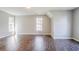Large bonus room with luxury vinyl plank flooring, two windows, and neutral paint at 3604 Cameron Hills Pl, Ellenwood, GA 30294