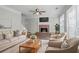 Bright living room features a cozy fireplace, comfortable seating, and large windows at 3604 Cameron Hills Pl, Ellenwood, GA 30294