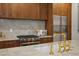 Close up of a kitchen with wood cabinets, marble backsplash and countertops, and stainless steel appliances at 531 Atlanta Se Ave, Atlanta, GA 30315