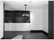 Modern kitchenette area with white cabinets, black countertops, pendant lighting and black hardwood floors at 199 14Th Ne St # 3003, Atlanta, GA 30309