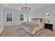 Well lit bedroom showcasing two windows, minimalist decor, wood flooring, and a gold chandelier at 345 Sugarview Rd, Sugar Hill, GA 30518