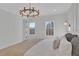 Bright bedroom with a modern chandelier, two windows, and neutral-toned bedding for a cozy aesthetic at 345 Sugarview Rd, Sugar Hill, GA 30518