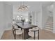 Elegant dining space with modern lighting fixtures, connecting to a stylish kitchen and stairway at 345 Sugarview Rd, Sugar Hill, GA 30518