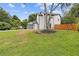 Spacious backyard featuring lush green grass, mature trees, and a wood fence at 1164 Red Oak Cv, Tucker, GA 30084