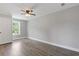 Bedroom features wood-look floors, neutral paint, and a ceiling fan with light at 1164 Red Oak Cv, Tucker, GA 30084