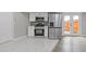 Beautiful kitchen features white cabinetry, stainless steel appliances, and backyard access at 1164 Red Oak Cv, Tucker, GA 30084