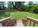 View of backyard with fence, green grass, and stairs leading to the outdoor living space at 2251 Rushmore Dr, Marietta, GA 30062