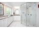 Bright white bathroom with a large glass shower, double vanity, and marble-patterned tile throughout at 2251 Rushmore Dr, Marietta, GA 30062