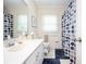 Bright bathroom with a single vanity, toilet, and bathtub with blue patterned shower curtain at 2251 Rushmore Dr, Marietta, GA 30062