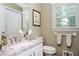 Cozy bathroom featuring a granite countertop sink, white cabinets, and a well-lit mirror at 2251 Rushmore Dr, Marietta, GA 30062
