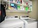 Functional laundry room with modern white appliances and ample shelving for storage at 2251 Rushmore Dr, Marietta, GA 30062