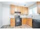 Functional kitchen with wooden cabinets, efficient appliances, and tiled backsplash at 914 Hemingway Rd, Stone Mountain, GA 30088