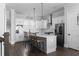Modern white kitchen features stainless steel appliances, an island with bar seating, and stylish pendant lighting at 2736 Bell Se Dr, Smyrna, GA 30080