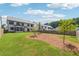 Expansive backyard with lush green grass, scattered trees, and a view of the home's exterior at 5340 Candun Cir, Sugar Hill, GA 30518
