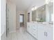 A bright bathroom features tile floors, a dual sink vanity with quartz countertops, and a glass enclosed shower at 5340 Candun Cir, Sugar Hill, GA 30518
