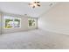 A spacious bedroom features neutral carpet, a ceiling fan, and bright natural light from two large windows at 5340 Candun Cir, Sugar Hill, GA 30518