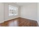 Cozy bedroom featuring hardwood floors, a window with blinds, and neutral paint at 5340 Candun Cir, Sugar Hill, GA 30518
