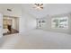 A spacious bedroom features neutral carpet, a ceiling fan, and bright natural light from two large windows at 5340 Candun Cir, Sugar Hill, GA 30518