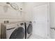 A well-lit laundry room features modern silver washer and dryer units with white shelving at 5340 Candun Cir, Sugar Hill, GA 30518