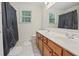 This bathroom features a double sink, tile flooring, and a shower behind a gray curtain at 3688 Eagles Beek Cir, Lithonia, GA 30038