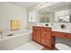 This bathroom features a soaking tub, wood vanity, and a makeup table with a comfortable stool at 3688 Eagles Beek Cir, Lithonia, GA 30038