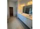 Bright bathroom boasts a double sink vanity and large mirrors plus tile floors and walk-in shower at 1857 Kingsmere Run Dr, Loganville, GA 30052