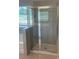 Bright bathroom features a tile shower with a glass door and large shower head with a window at 1857 Kingsmere Run Dr, Loganville, GA 30052