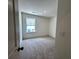 Cozy bedroom featuring neutral carpet, ample natural light from a large window, and fresh white walls at 1909 Victoria Way # 116, Conyers, GA 30013