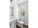 Compact powder room with pedestal sink, toilet and a window with blinds at 1190 Buice Lake Pkwy, Acworth, GA 30102