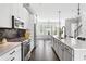 Gourmet kitchen boasts modern appliances, sleek countertops, and an open layout to the dining area at 1190 Buice Lake Pkwy, Acworth, GA 30102