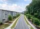Street view of modern townhomes with sidewalks and greenery lining the street, showcasing community living at 1190 Buice Lake Pkwy, Acworth, GA 30102