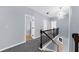 Bright hallway features a decorative light fixture, dark wood railing and staircase with grey carpet at 5345 Mirror Lake Dr, Cumming, GA 30028