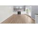 Bright living room with wooden floor, white cabinets, built in mini fridge and access to the outdoor patio at 5345 Mirror Lake Dr, Cumming, GA 30028