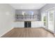 Bright living room with wooden floor, white cabinets, built in mini fridge and access to the outdoor patio at 5345 Mirror Lake Dr, Cumming, GA 30028