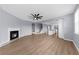 Open-concept living room featuring a fireplace, ceiling fan, and seamless transition to the kitchen area at 5345 Mirror Lake Dr, Cumming, GA 30028