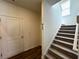 Hallway featuring a staircase, modern flooring, and access to storage, seamlessly connecting different living spaces at 1911 Victoria Way # 117, Conyers, GA 30013