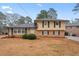 Charming two-story home featuring a brick facade, yellow siding, and manicured front yard, perfect for curb appeal at 2002 Twin Falls Rd, Decatur, GA 30032