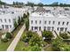 Stunning aerial view of a white brick townhouse community with beautifully landscaped yards and inviting outdoor patios at 323 S Esplanade, Alpharetta, GA 30009