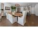 Open-concept dining area with a wooden table, six white chairs, and views into the kitchen at 323 S Esplanade, Alpharetta, GA 30009