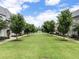 Scenic neighborhood view of a sprawling green lawn lined with trees and elegant homes in the background at 323 S Esplanade, Alpharetta, GA 30009