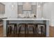 Stylish kitchen island with bar stool seating, pendant lighting, and white countertops at 323 S Esplanade, Alpharetta, GA 30009