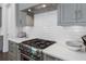 Close-up of a modern kitchen stove with stainless steel hood and white subway tile backsplash at 323 S Esplanade, Alpharetta, GA 30009