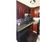 Well-lit kitchen featuring dark wood cabinets, granite countertops, and stainless steel appliances at 4701 Flat Shoals Rd # 25F, Union City, GA 30291