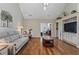 Bright living room with hardwood floors, neutral sofa, entertainment center, and seamless flow to another room at 299 Saint Marys Nw Ln, Marietta, GA 30064
