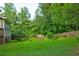 Landscaped backyard with lush greenery, mature trees, and a shed at 1137 Eagles Nest Cir, Carrollton, GA 30116